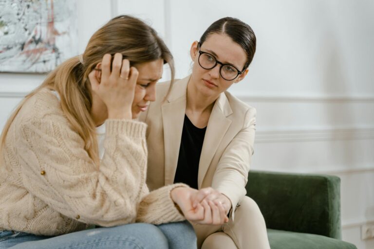 A woman receives counseling from a professional, showcasing empathy and mental health support.