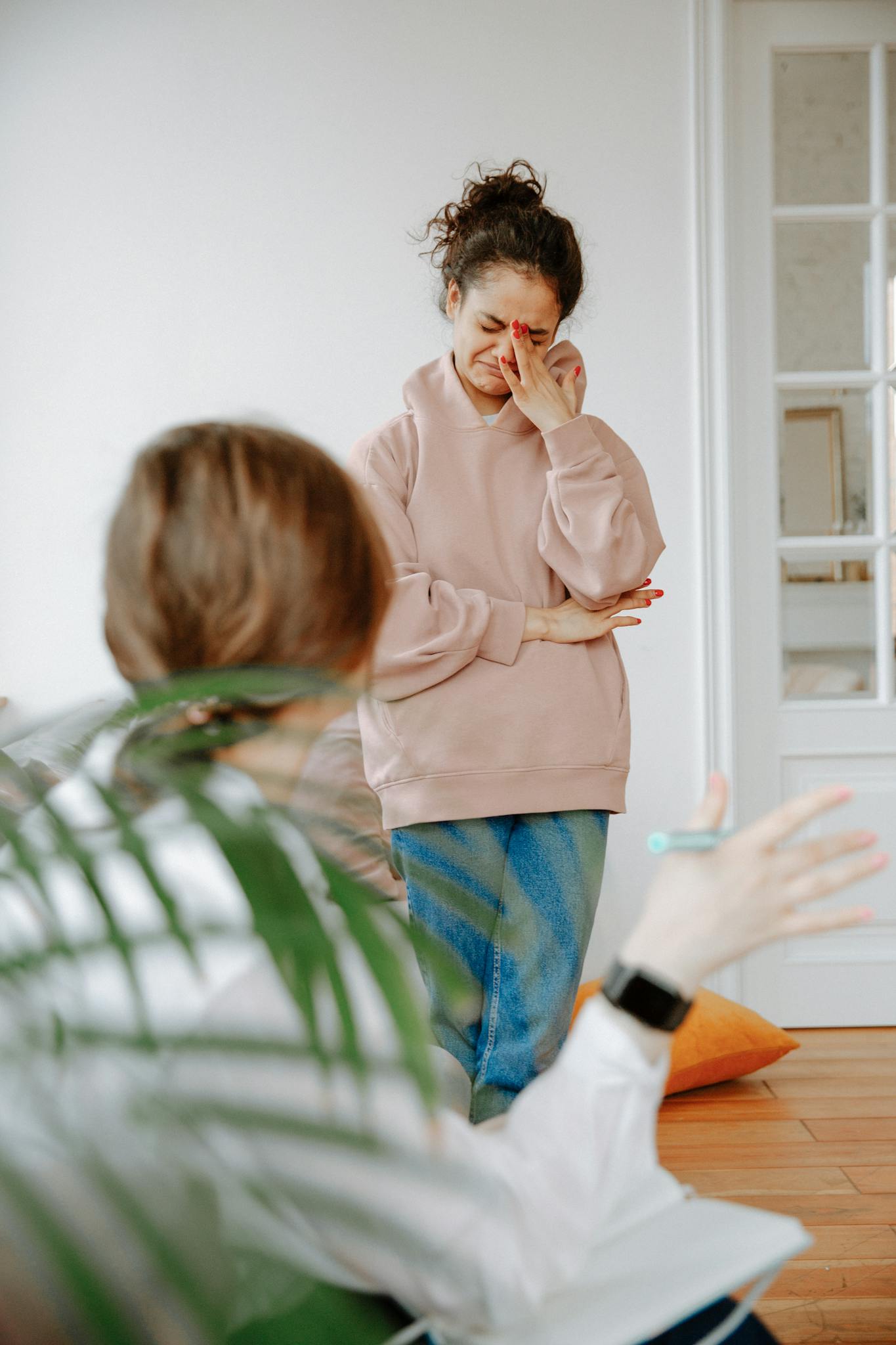 Young woman in therapy session expressing emotions indoors.